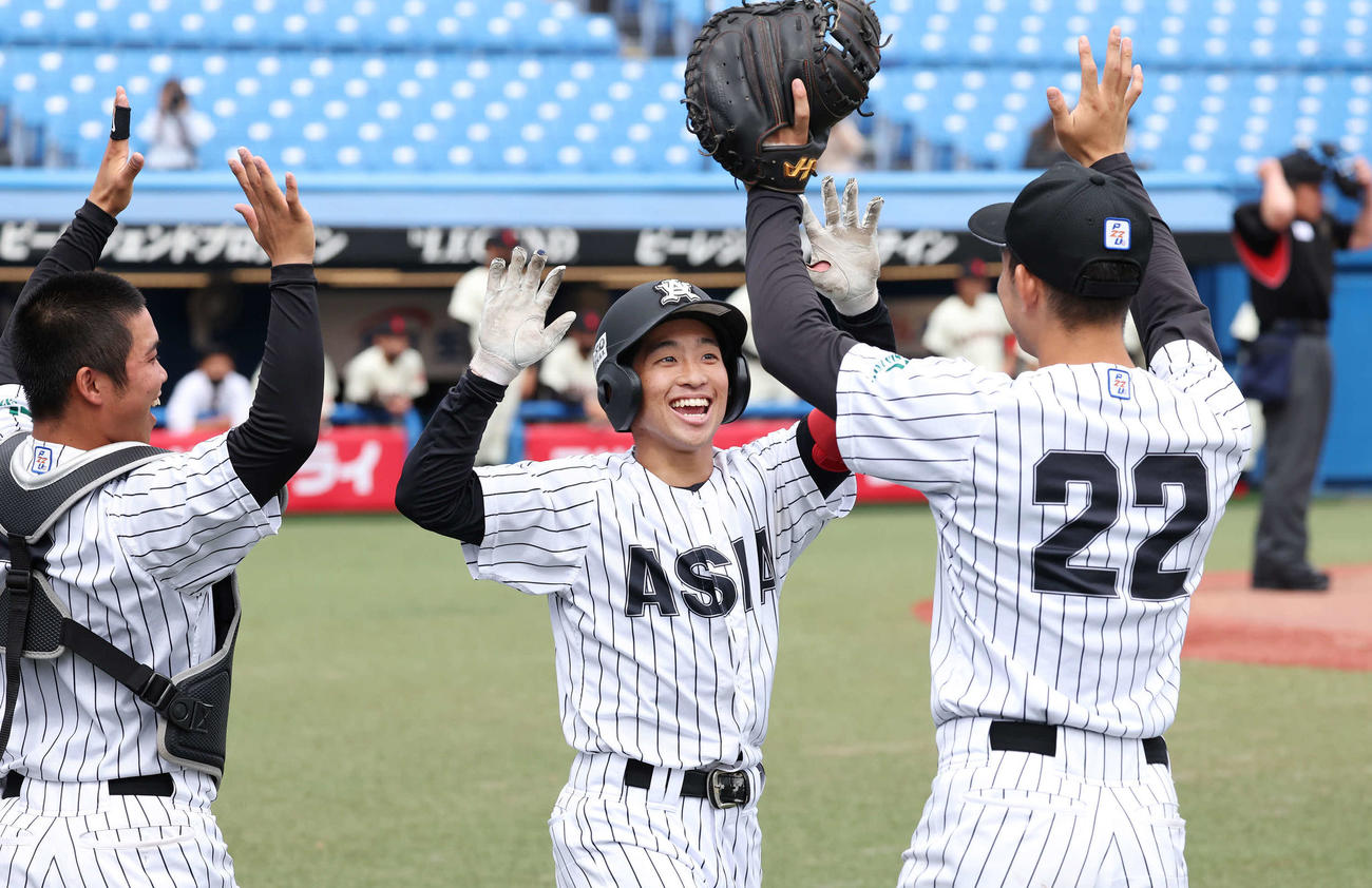 日大対亜大　1回裏亜大1死、田中幹（中央）は左越えに先制本塁打を放って仲間の祝福を受ける（撮影・丹羽敏通）
