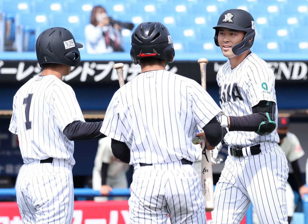 日大対亜大　2回裏亜大1死一、二塁、藤江（右）は左越えに3点本塁打を放って次打者田中幹（左）らに迎えられる（撮影・丹羽敏通）