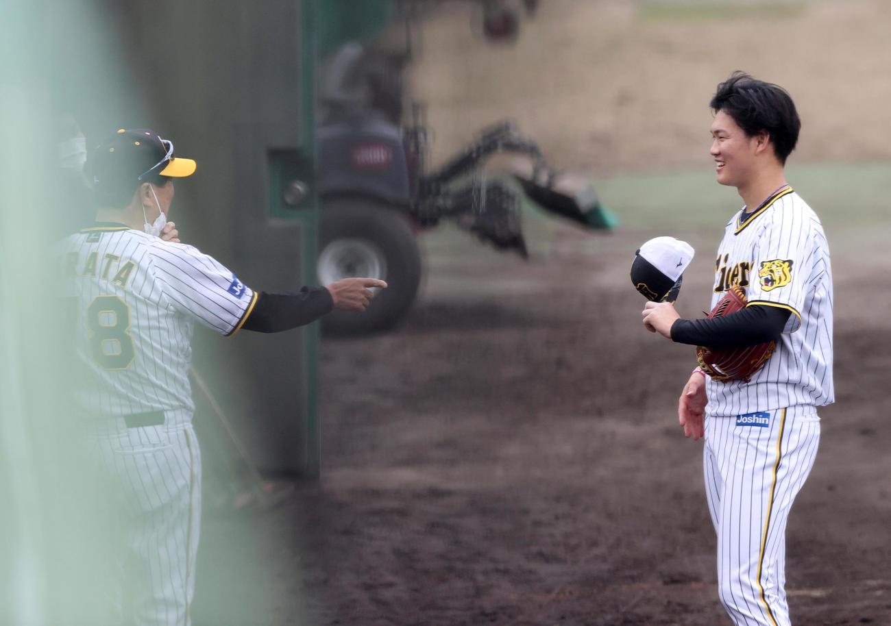 シート打撃の登板を終えた及川雅貴（右）は平田勝男2軍監督から声をかけられ笑顔を見せる（撮影・上山淳一）