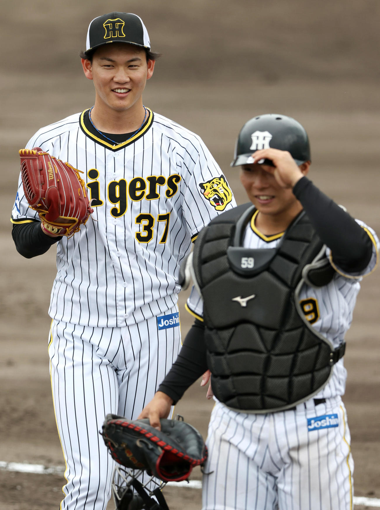シート打撃の登板を終え笑顔を見せる及川雅貴。右は藤田健斗（撮影・上山淳一）