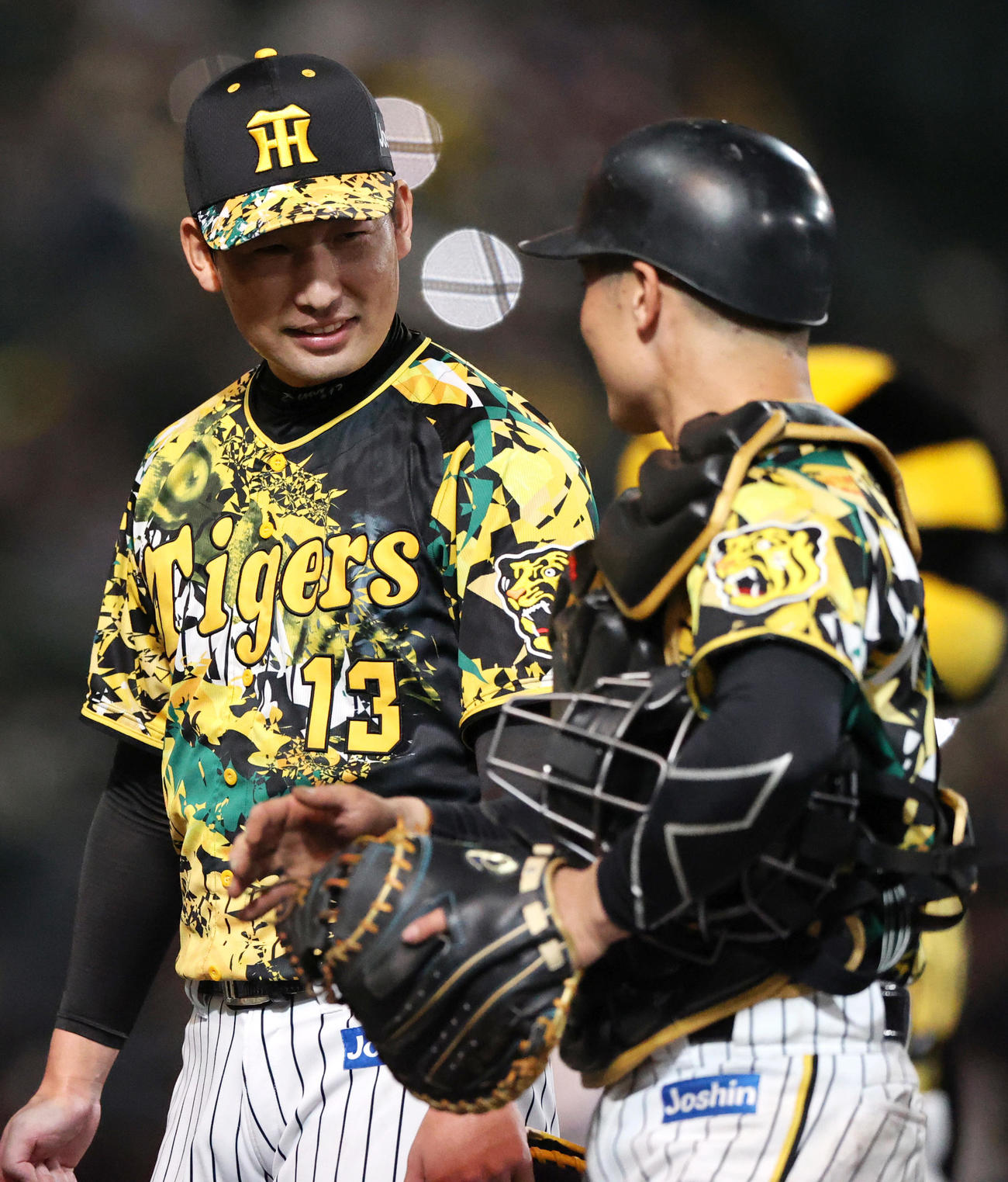 阪神対中日　9回に登板し、無失点ピッチングで締めた岩阪神崎（左）は坂本と笑顔で話す（撮影・上山淳一）