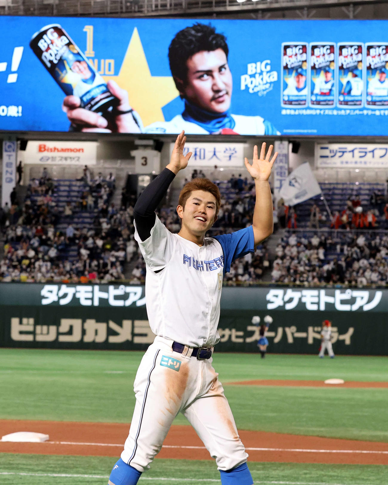 日本ハム対オリックス　この日2本塁打の今川は場内1周で、新庄監督の看板を背に笑顔で手を振る（撮影・浅見桂子）