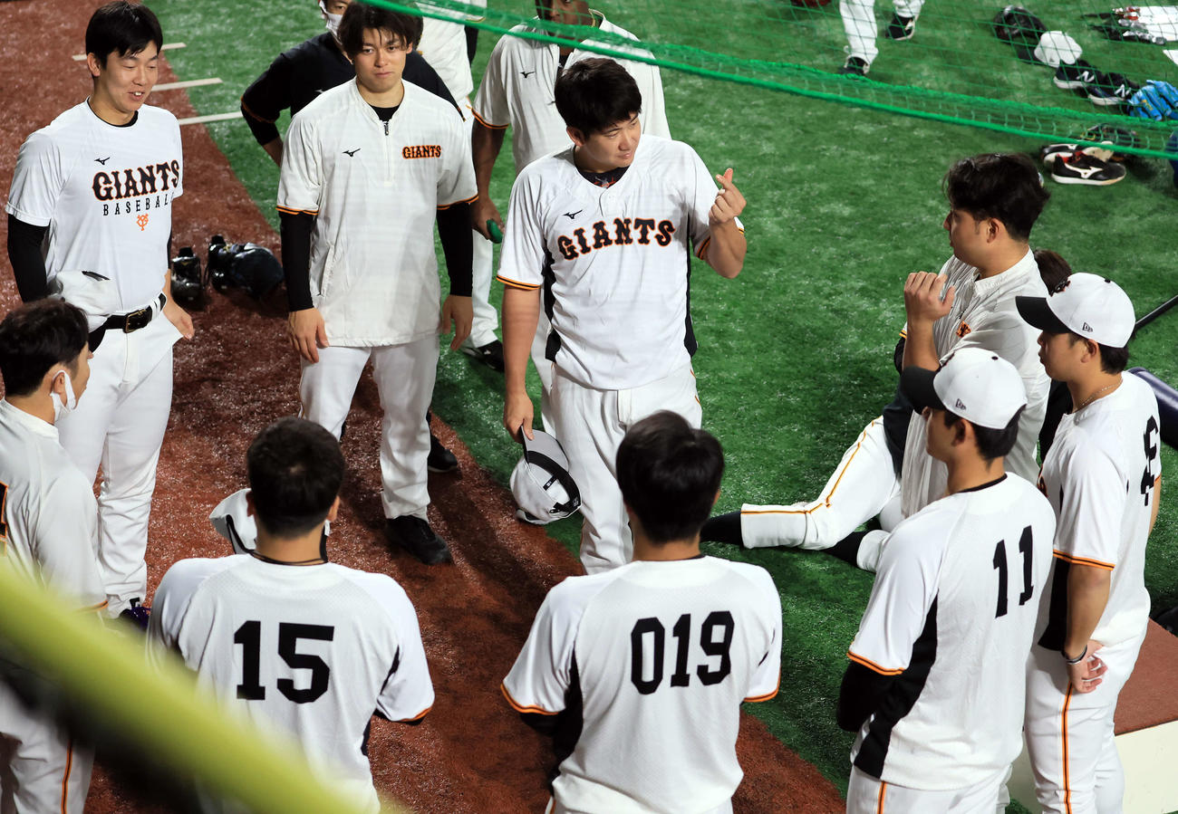 巨人対阪神　練習前円陣で、指でマークを作りあいさつする巨人菅野（中央）（撮影・浅見桂子）
