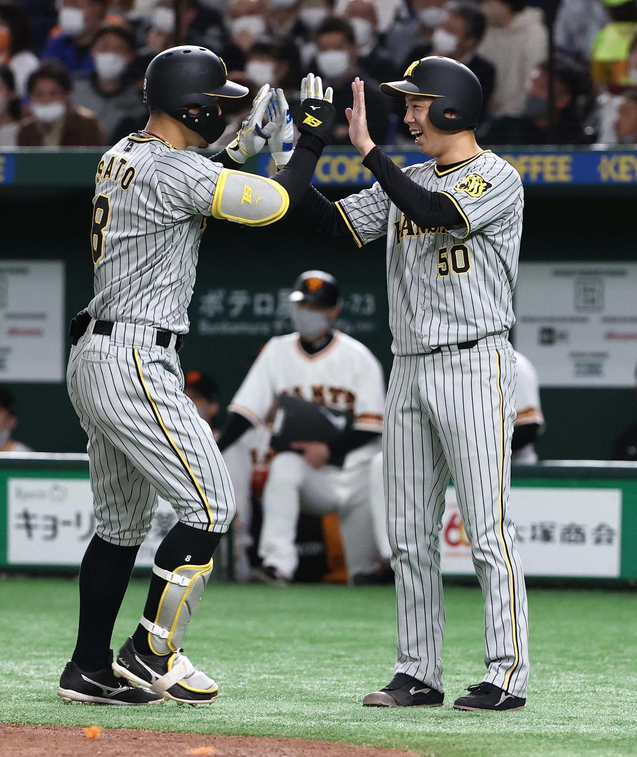 巨人対阪神　3回表阪神2死一塁、左越えに先制2点本塁打を放った佐藤輝（左）を笑顔で出迎える青柳（撮影・上田博志）