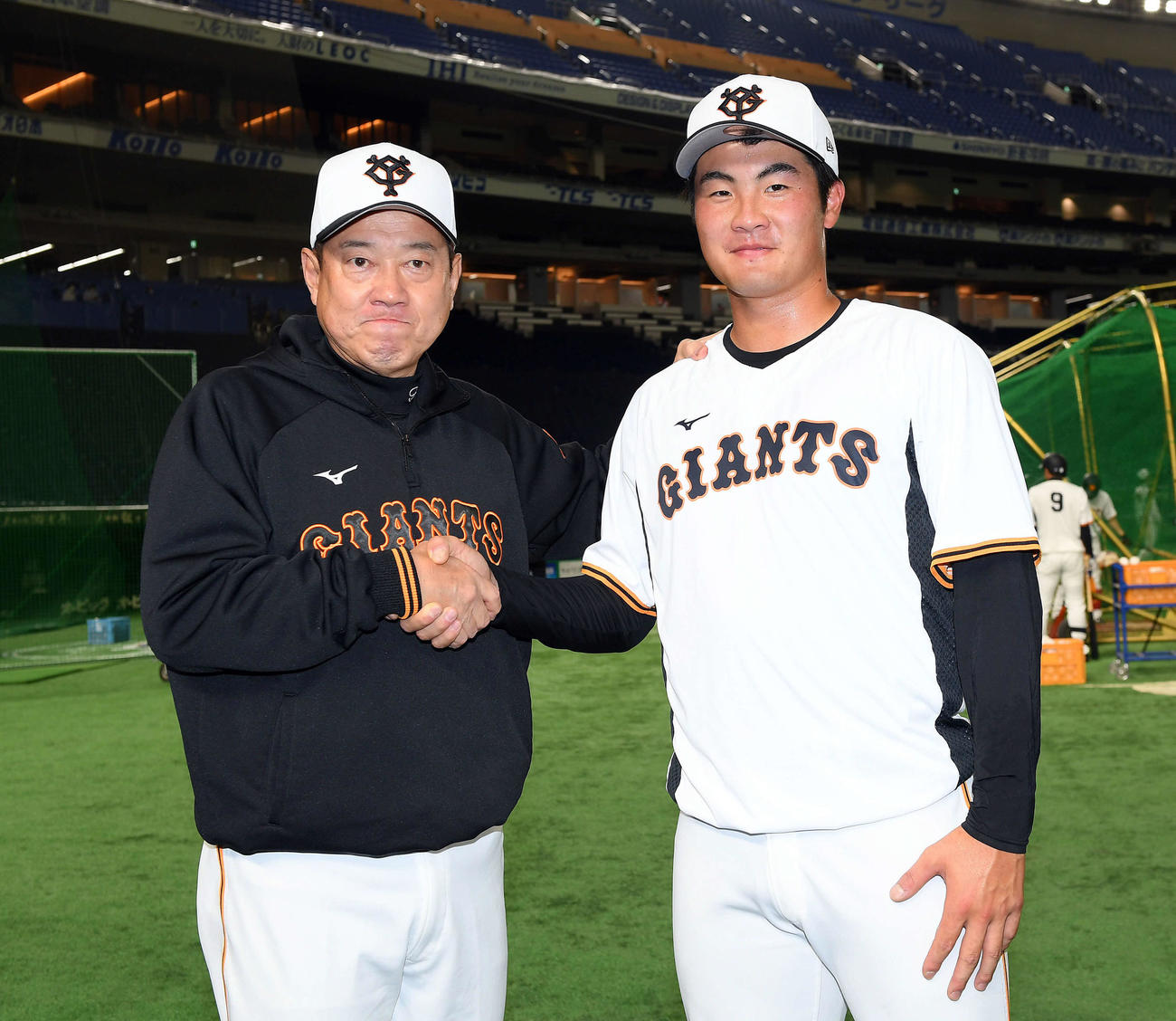 支配下選手登録された巨人菊地（右）は、原監督とがっちりと握手を交わす（撮影・たえ見朱実）