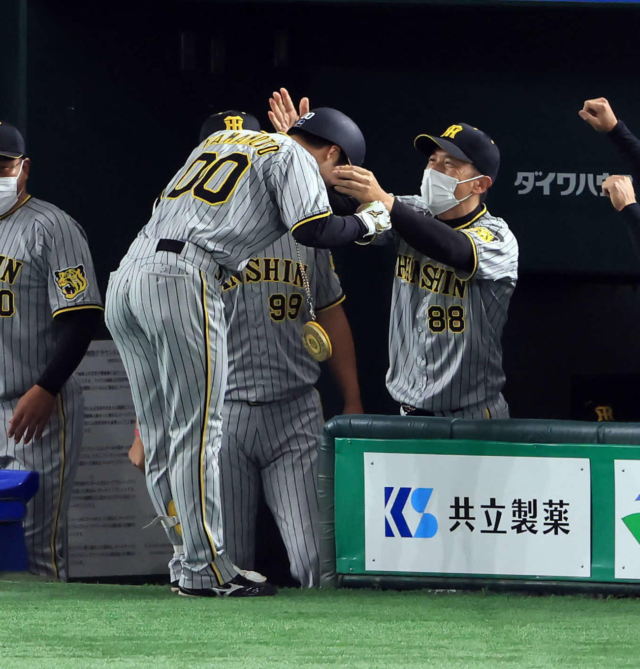 巨人対阪神　8回表阪神1死一塁、山本（左）が左越え2点本塁打を放ち、笑顔でメダルをかける矢野監督（撮影・浅見桂子）