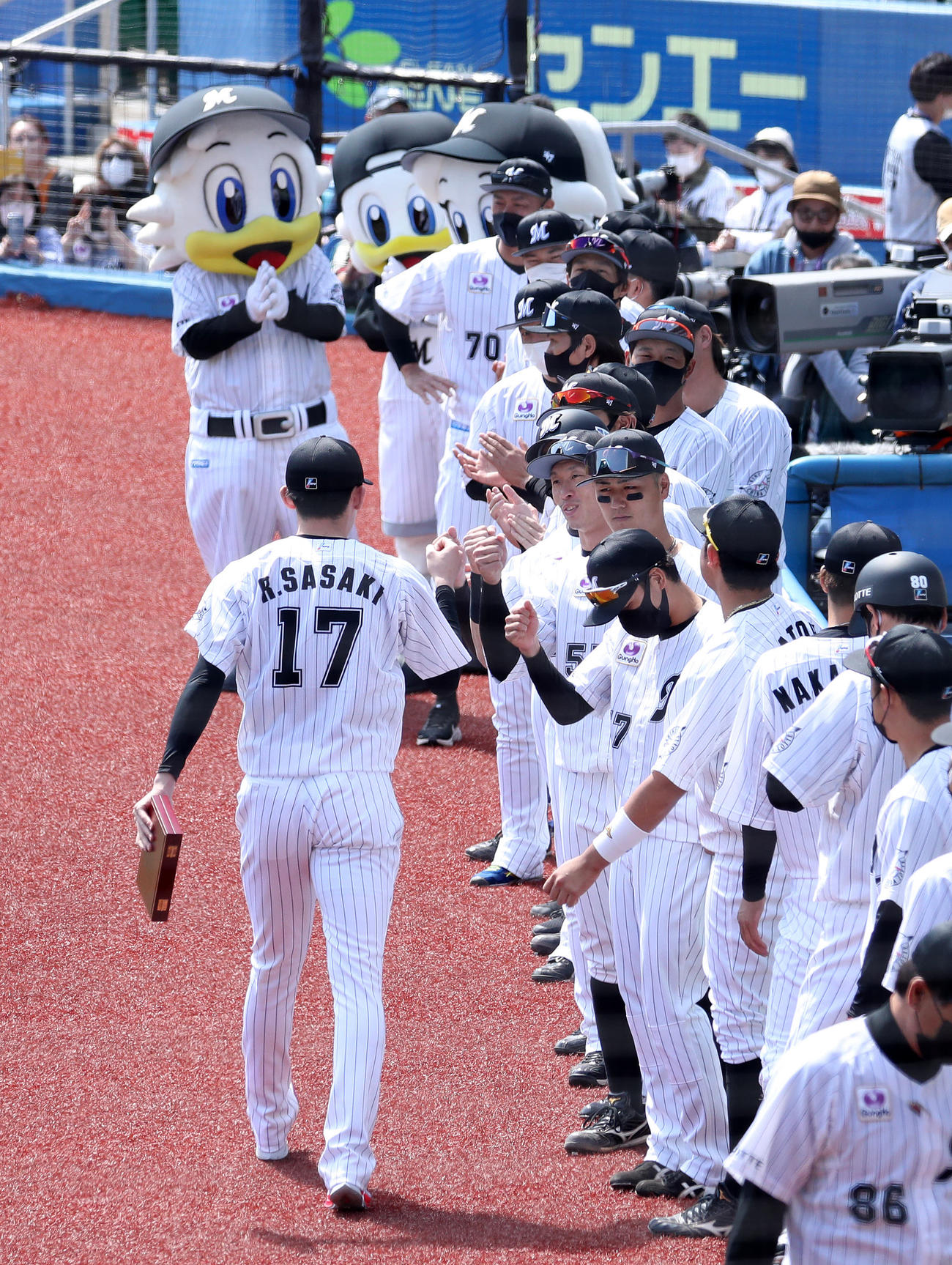 ロッテ対日本ハム　完全試合の表彰を受け選手たちに迎えられるロッテ佐々木朗希（撮影・鈴木正人）