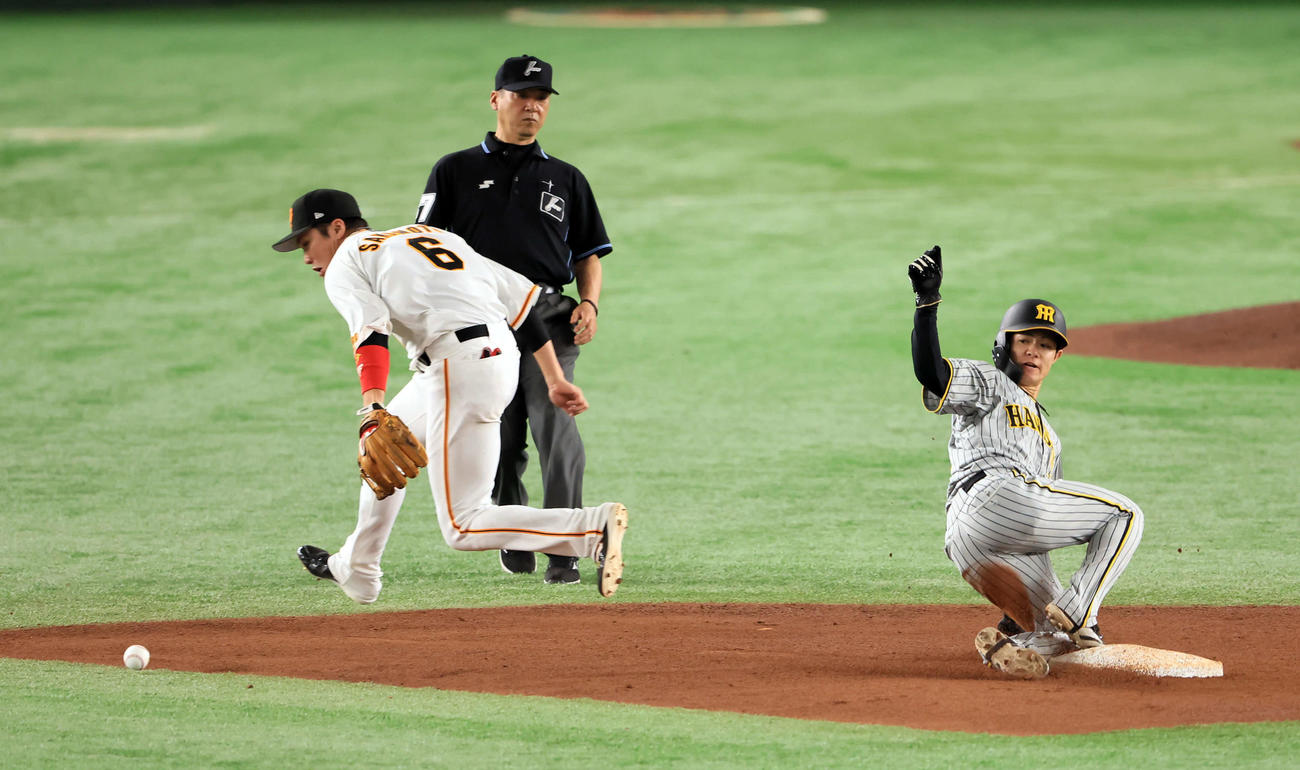 巨人対阪神　4回表阪神無死一、三塁、打者佐藤輝の時、一塁走者中野（手前）が二塁盗塁。捕手大城の悪送球を呼び、三塁走者近本が生還する。遊撃手坂本（撮影・浅見桂子）