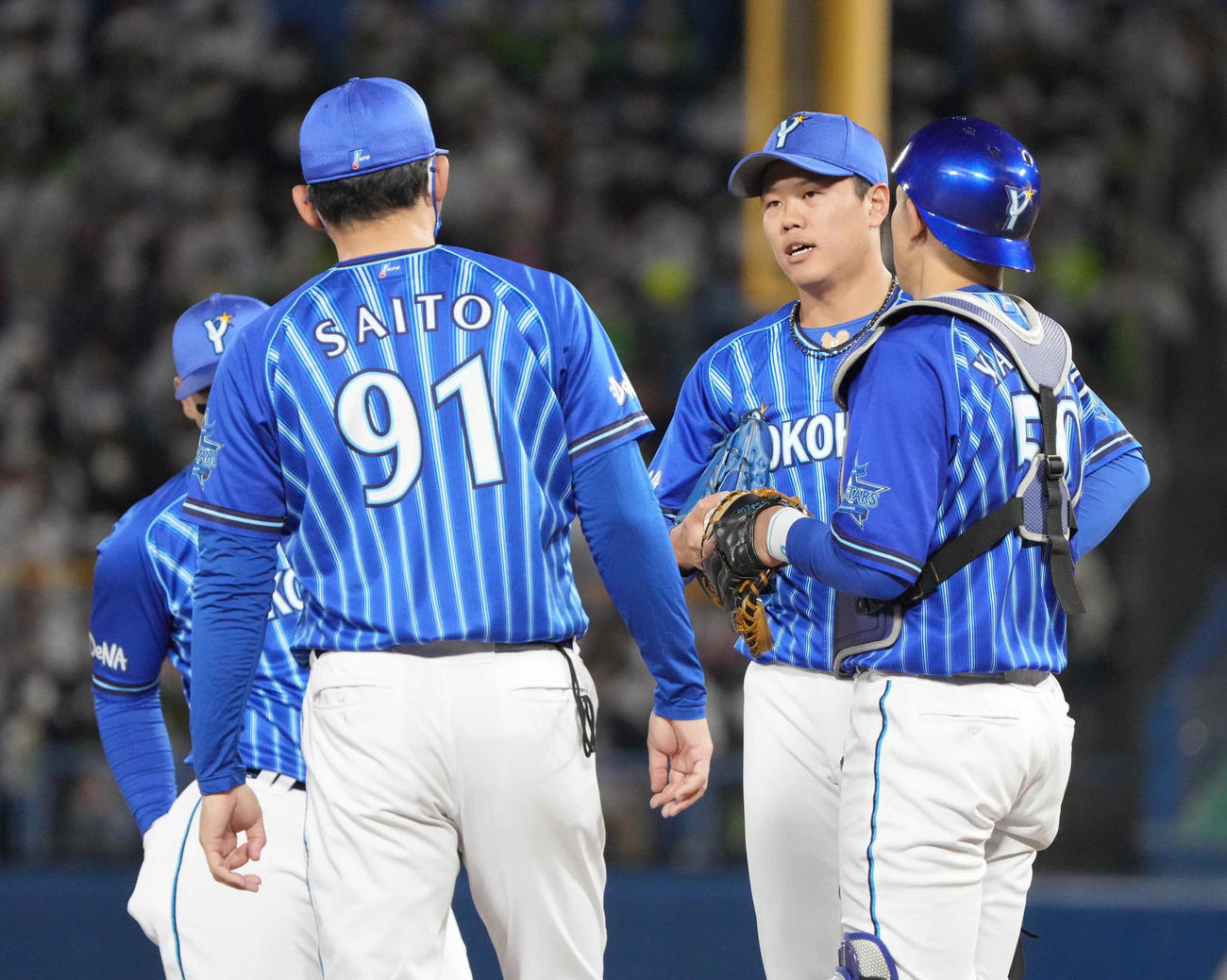ヤクルト対DeNA 3回裏ヤクルト2死二、三塁、DeNA先発の上茶谷大河（右から2人目）は斎藤隆投手コーチ（左）から激励を受ける（撮影・小沢裕）