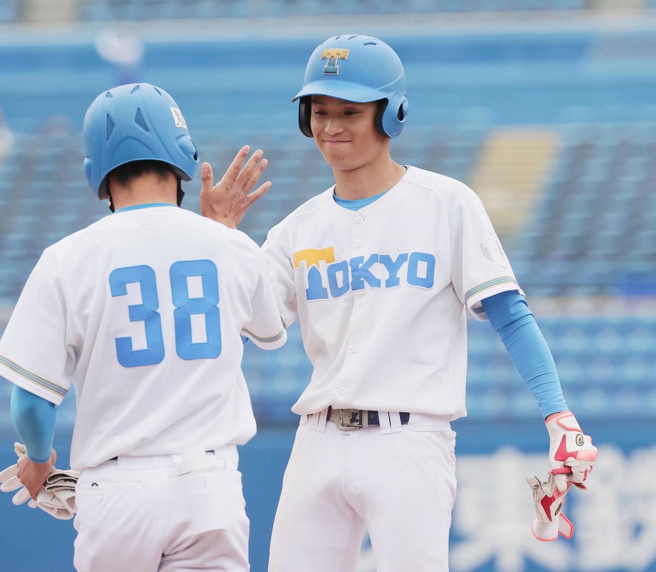 東大対早大　2回表東大2死二、三塁、右前適時打を放ち一塁コーチャーとタッチする中井（撮影・野上伸悟）