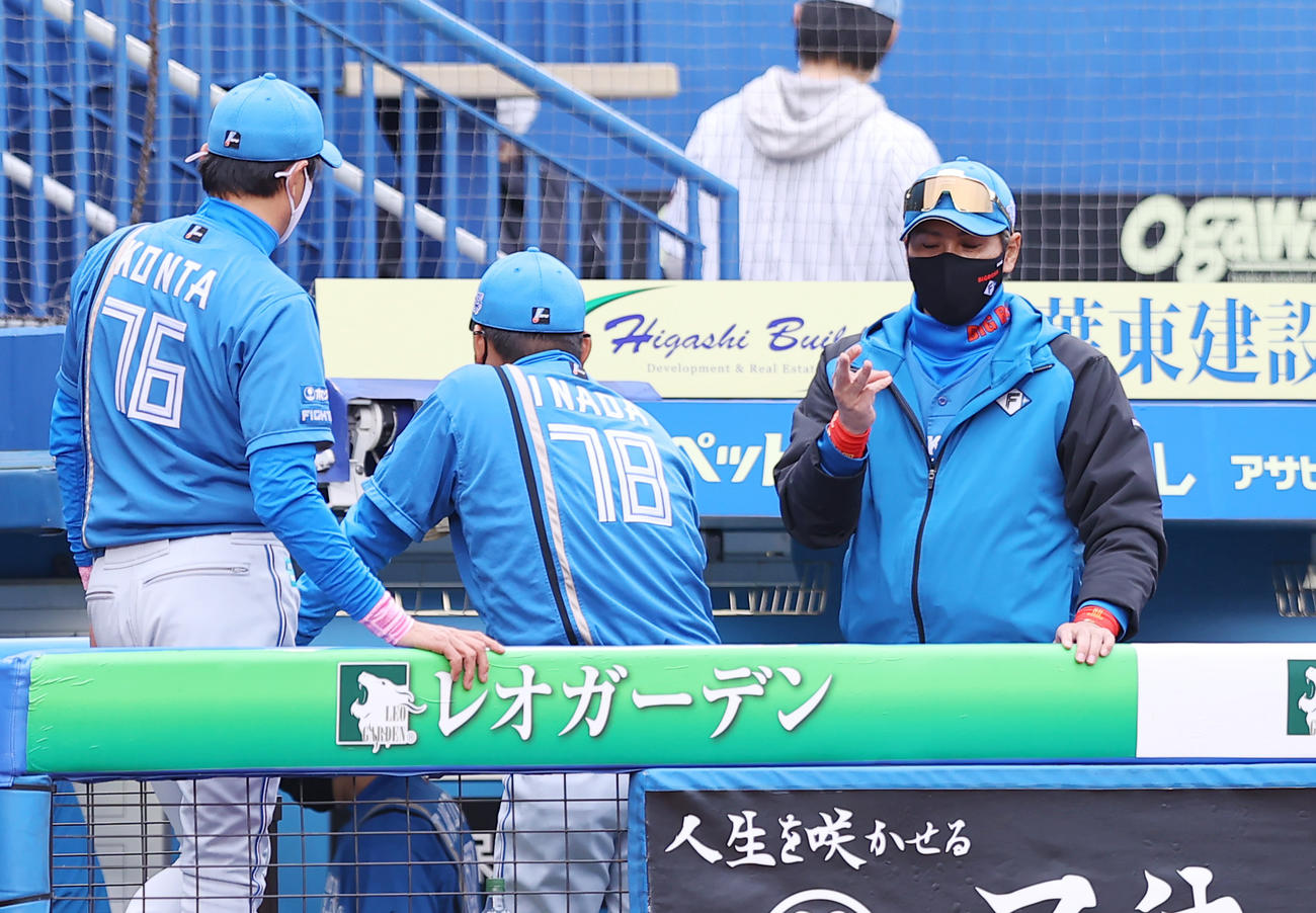 ロッテ対日本ハム　6回裏ロッテ1死一、二塁、西村が右手を負傷し自身の右手を見つめる新庄監督（右）（撮影・垰建太）