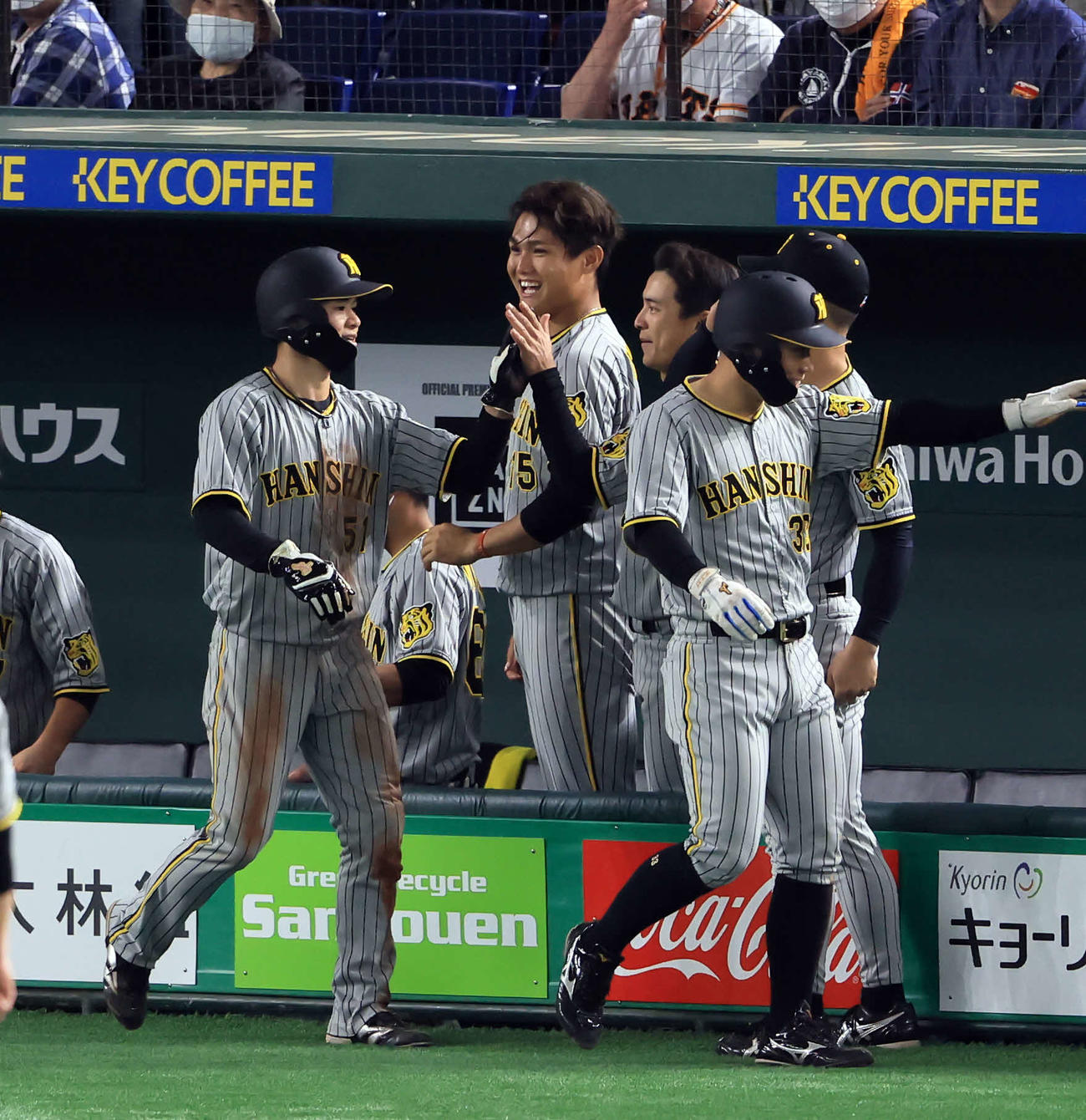 巨人対阪神　8回表阪神1死満塁、糸井の2点適時打で生還した糸原（手前右）らを笑顔で迎える西純（中央）（撮影・浅見桂子）