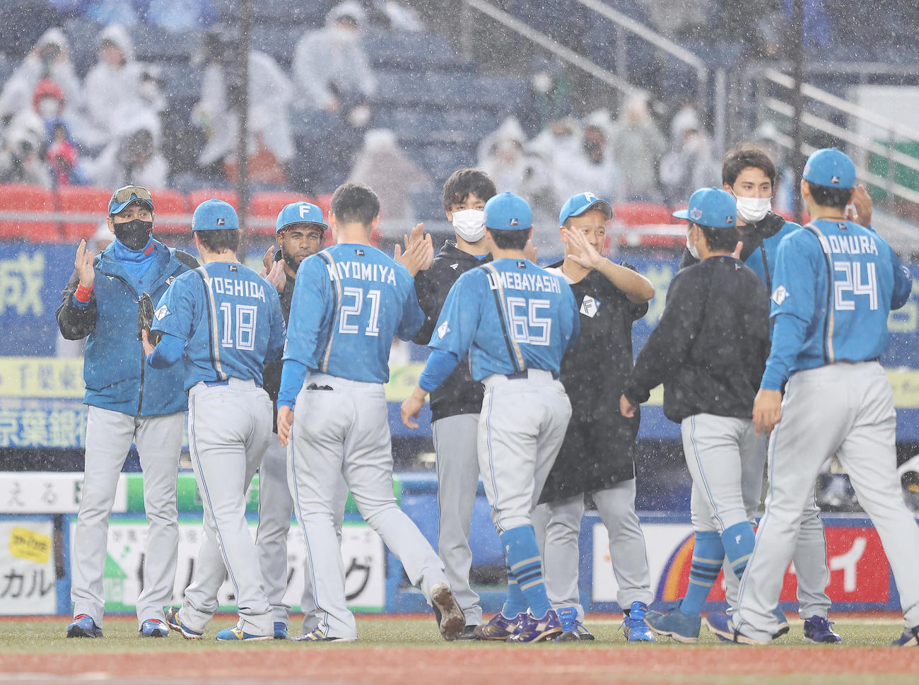 ロッテ対日本ハム　ロッテに勝利し雨の中ナインを出迎える日本ハム新庄監督（左）（撮影・垰建太）