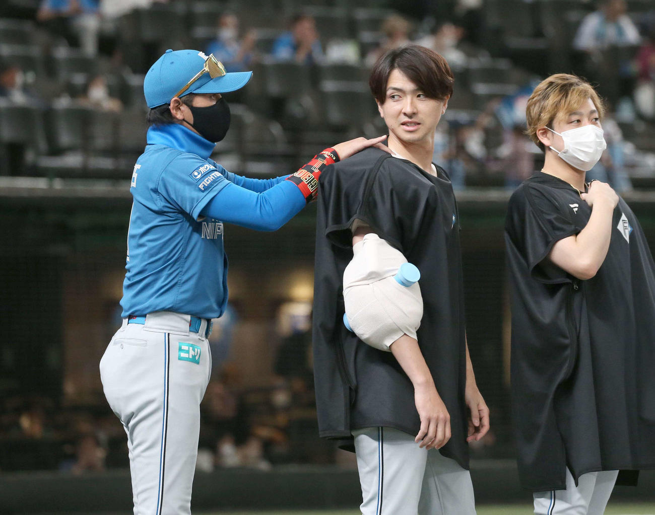 西武対日本ハム　試合後、今季初勝利の上沢（中央）の肩をもむ新庄監督（左）（撮影・黒川智章）