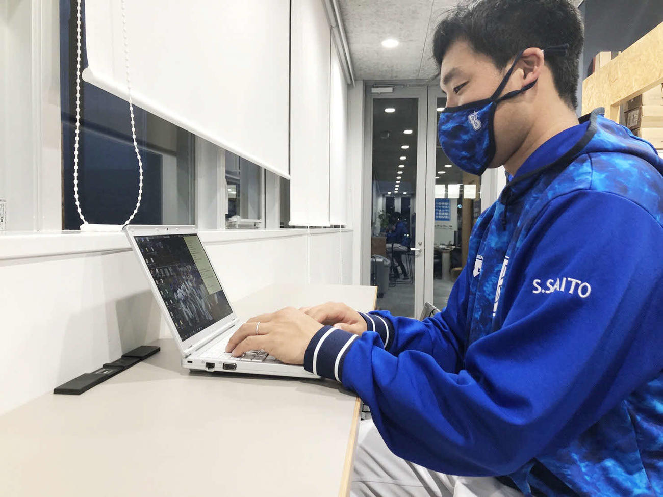 パソコンで仕事するDeNA斎藤ファームサブマネジャー（球団提供）