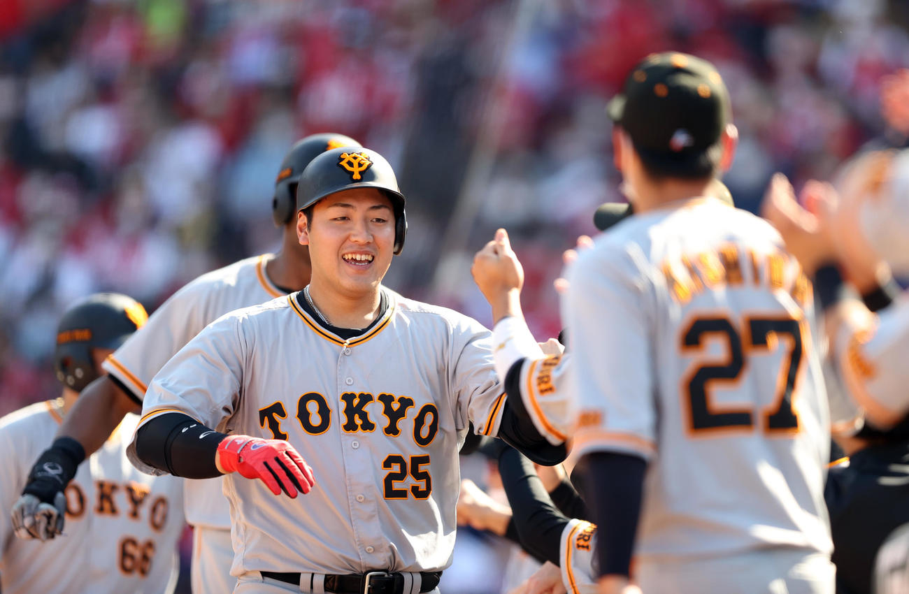 広島対巨人　6回表巨人無死一、二塁、3点本塁打を放ち、岸田行倫（右）らとタッチを交わす岡本和（撮影・狩俣裕三）