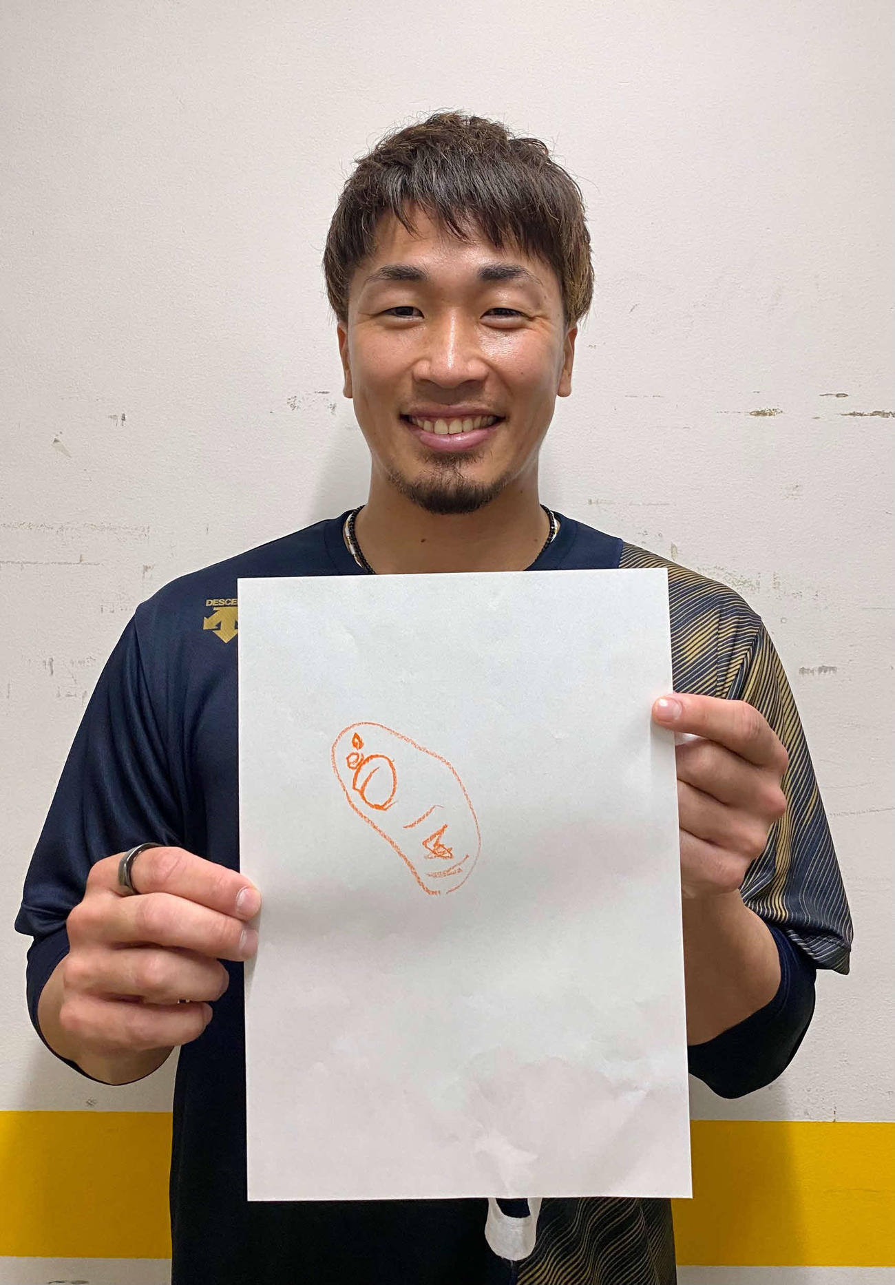 3歳の長男が描いたパパの似顔絵を持つオリックス安達了一内野手（球団提供）