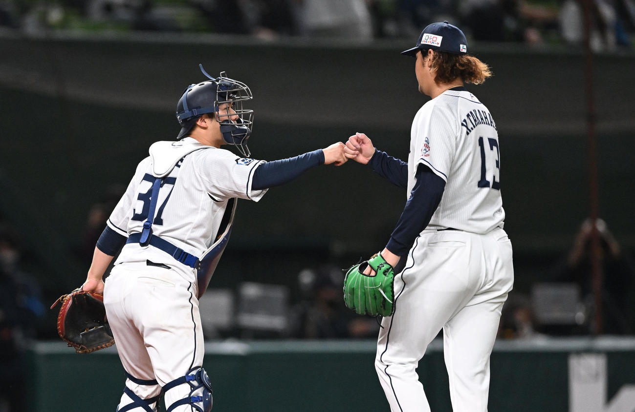 西武対日本ハム　7回を投げ終え西武捕手の柘植（左）とタッチを交わす高橋（撮影・滝沢徹郎）
