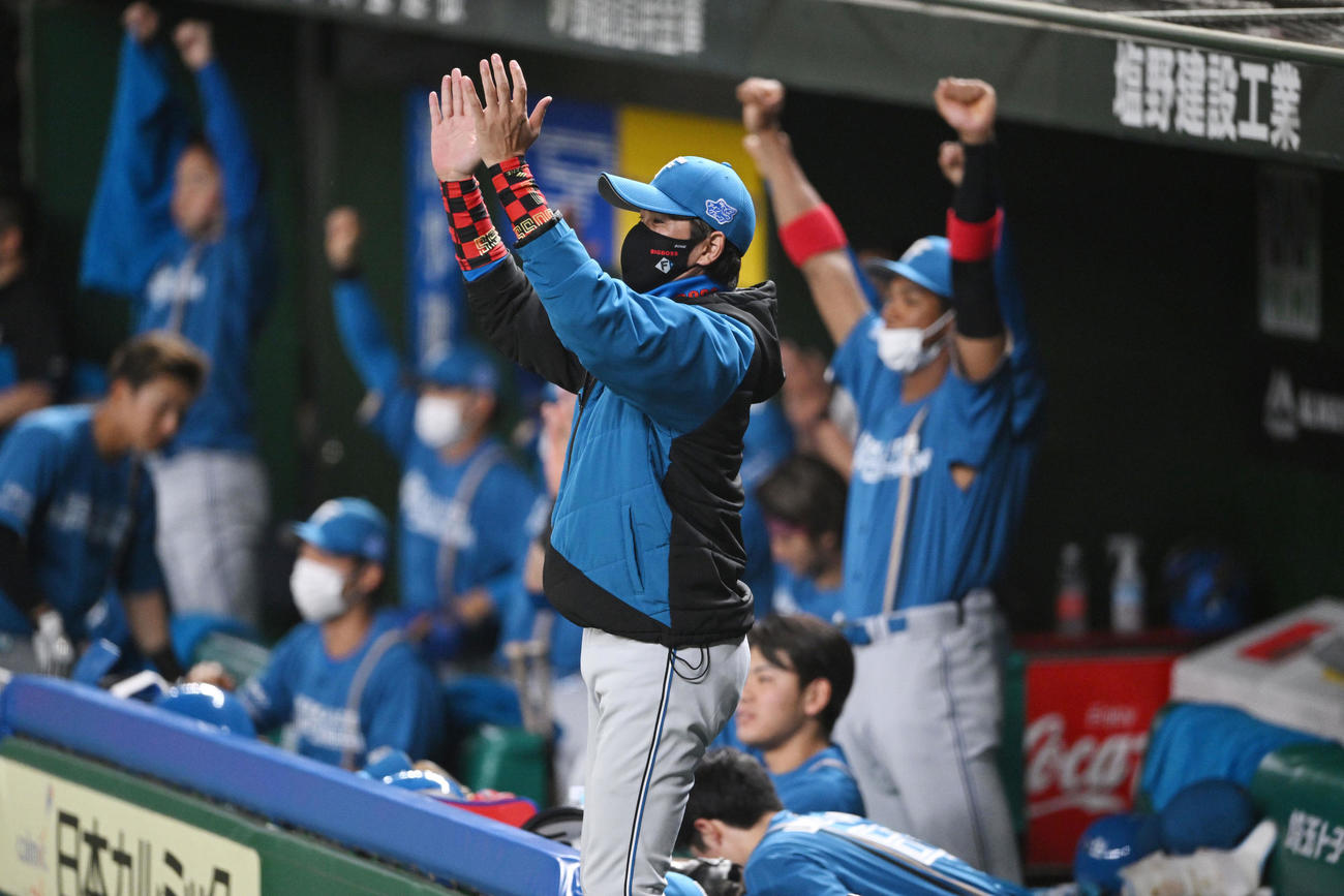 西武対日本ハム　5回表日本ハム1死、石井の三塁打に拍手を送る新庄監督（手前）（撮影・滝沢徹郎）