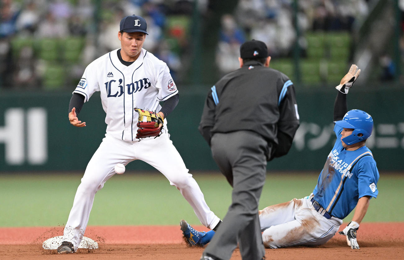 西武対日本ハム　6回表日本ハム無死一塁、平井の送球したボールを取り損ね今川（右）の二進を許す遊撃手中山（撮影・滝沢徹郎）