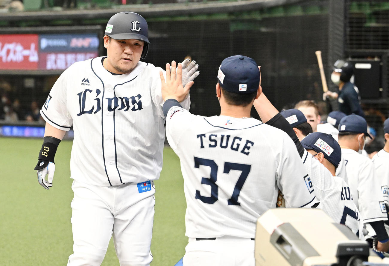 4回裏西武無死、中越えソロ本塁打を放った中村（左）は生還しナインとタッチを交わす（撮影・滝沢徹郎）
