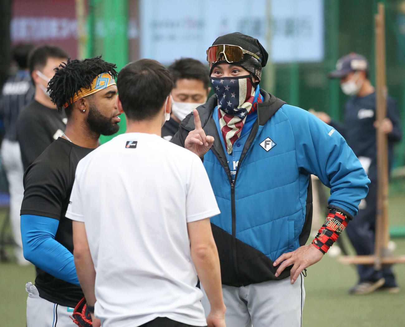 西武対日本ハム　星条旗柄のマスクをつけアルカンタラ（左）と話す新庄監督（撮影・黒川智章）