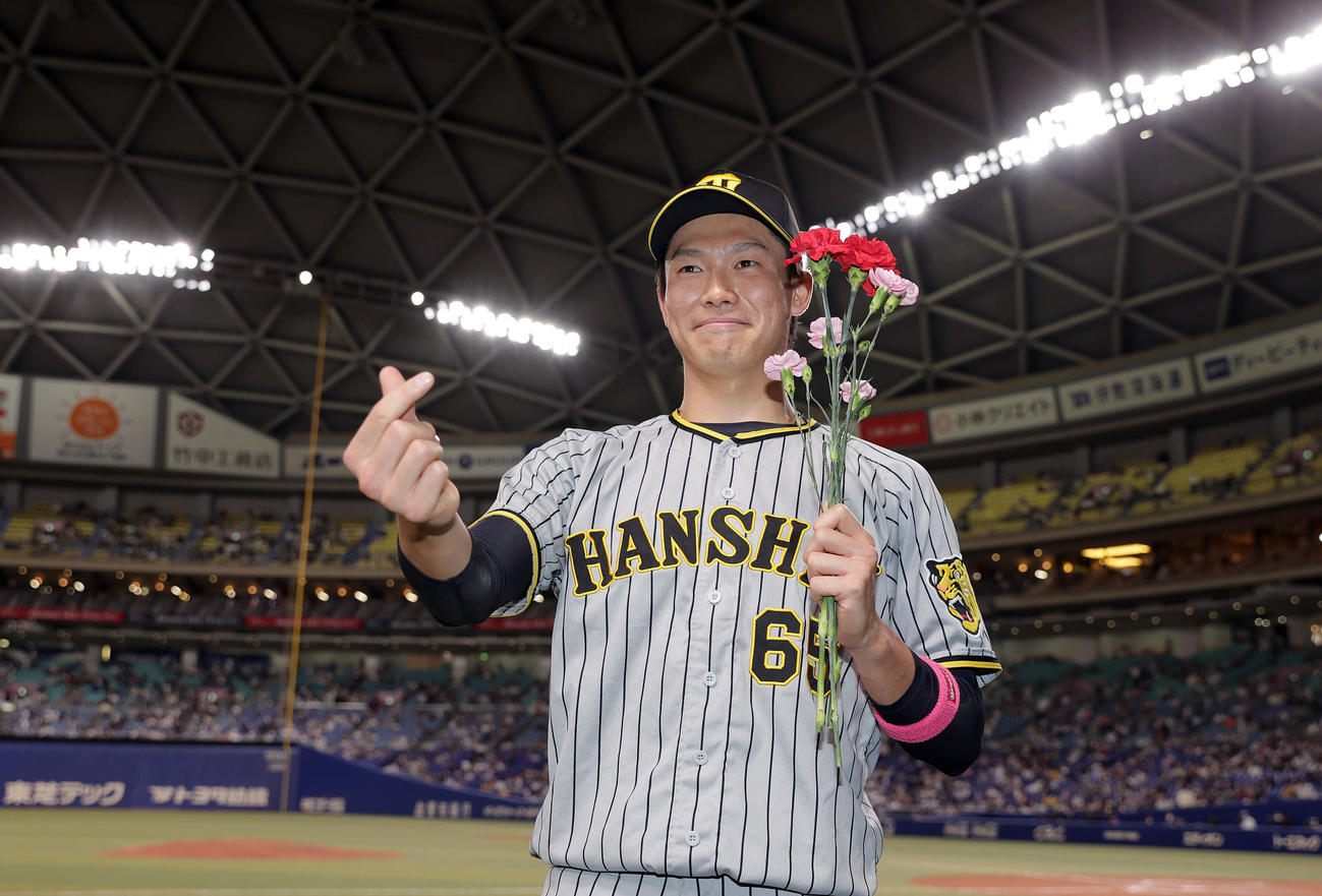 中日対阪神　ヒーローインタビューを終え、カーネーションを手に笑顔でポーズを決める阪神湯浅（撮影・前田充）