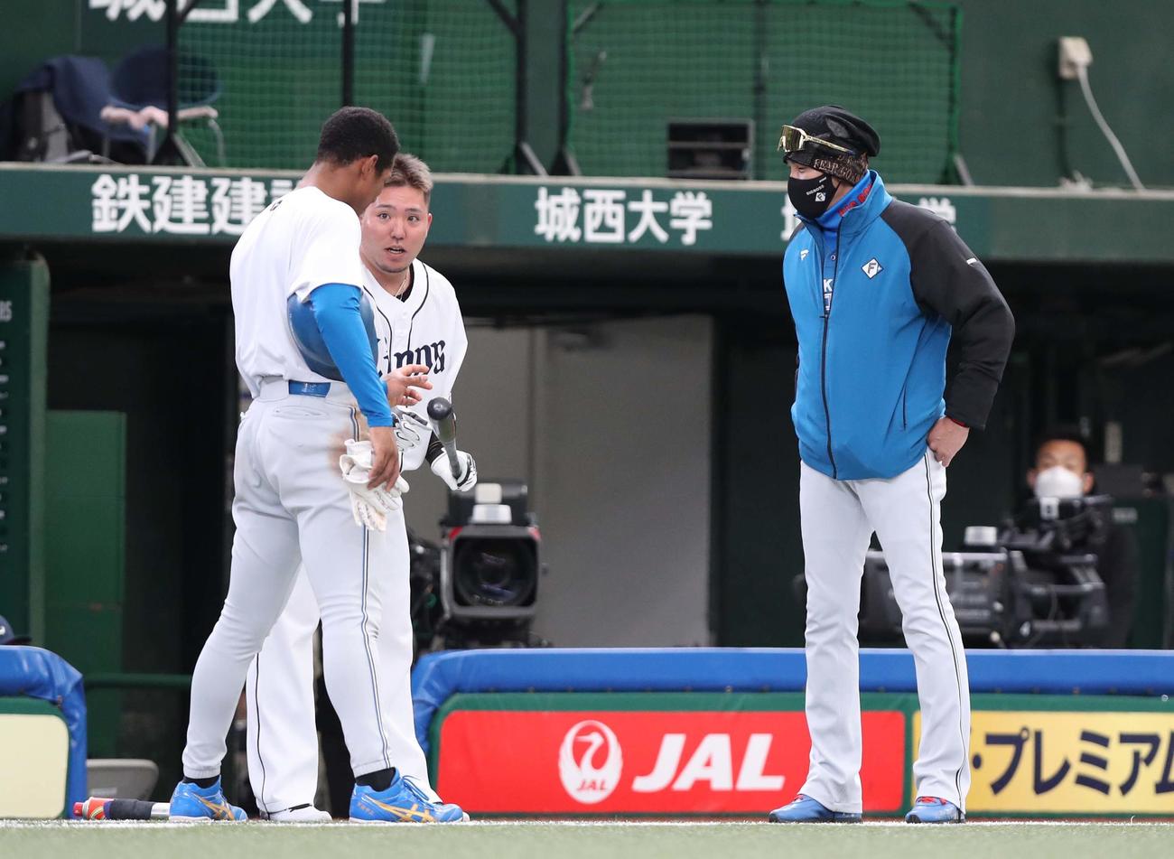 試合前、日本ハム新庄監督（右）に呼ばれ、西武山川（中央）から打撃指導を受ける万波（撮影・黒川智章）