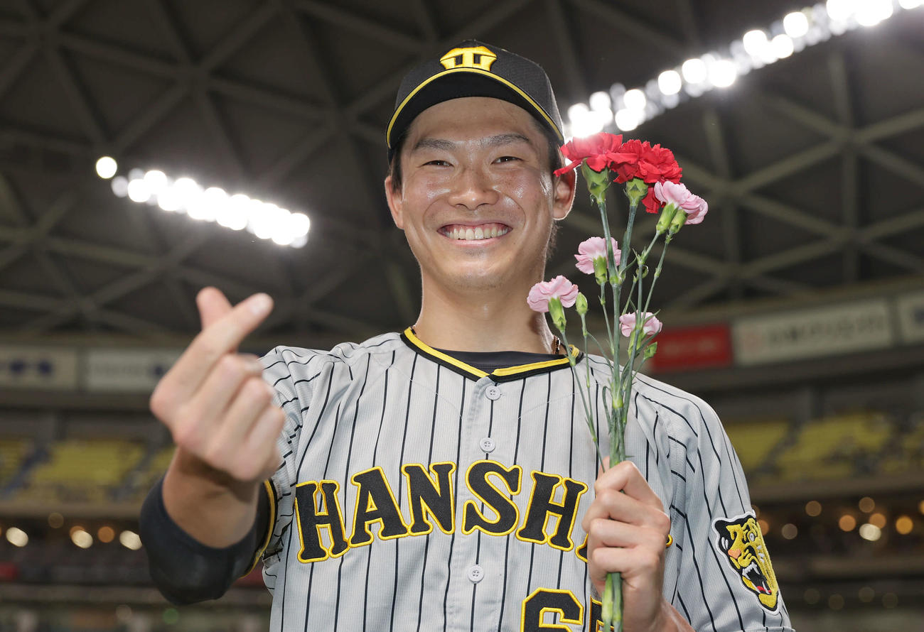 中日対阪神　ヒーローインタビューを終え、カーネーションを手に笑顔でポーズを決める阪神湯浅（撮影・前田充）