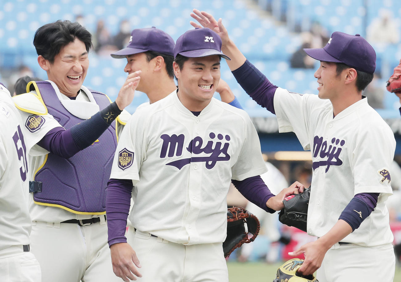 法大対明大　初完封勝利を挙げた明大・蒔田（中央）は、菅原（左）、長南（右）らに祝福され笑顔（撮影・野上伸悟）