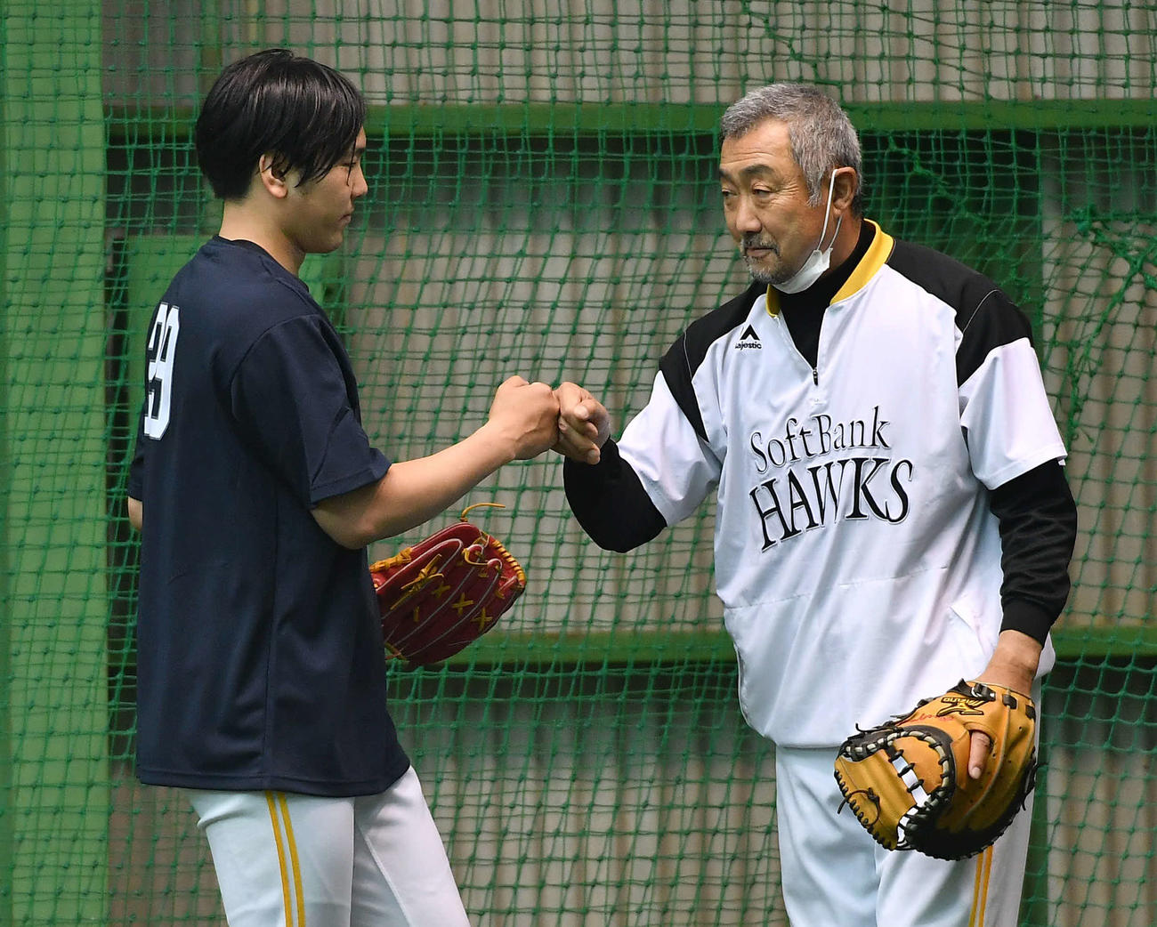 森山コーチ（右）とのキャッチボールを終えてグータッチを交わす石川（撮影・岩下翔太）