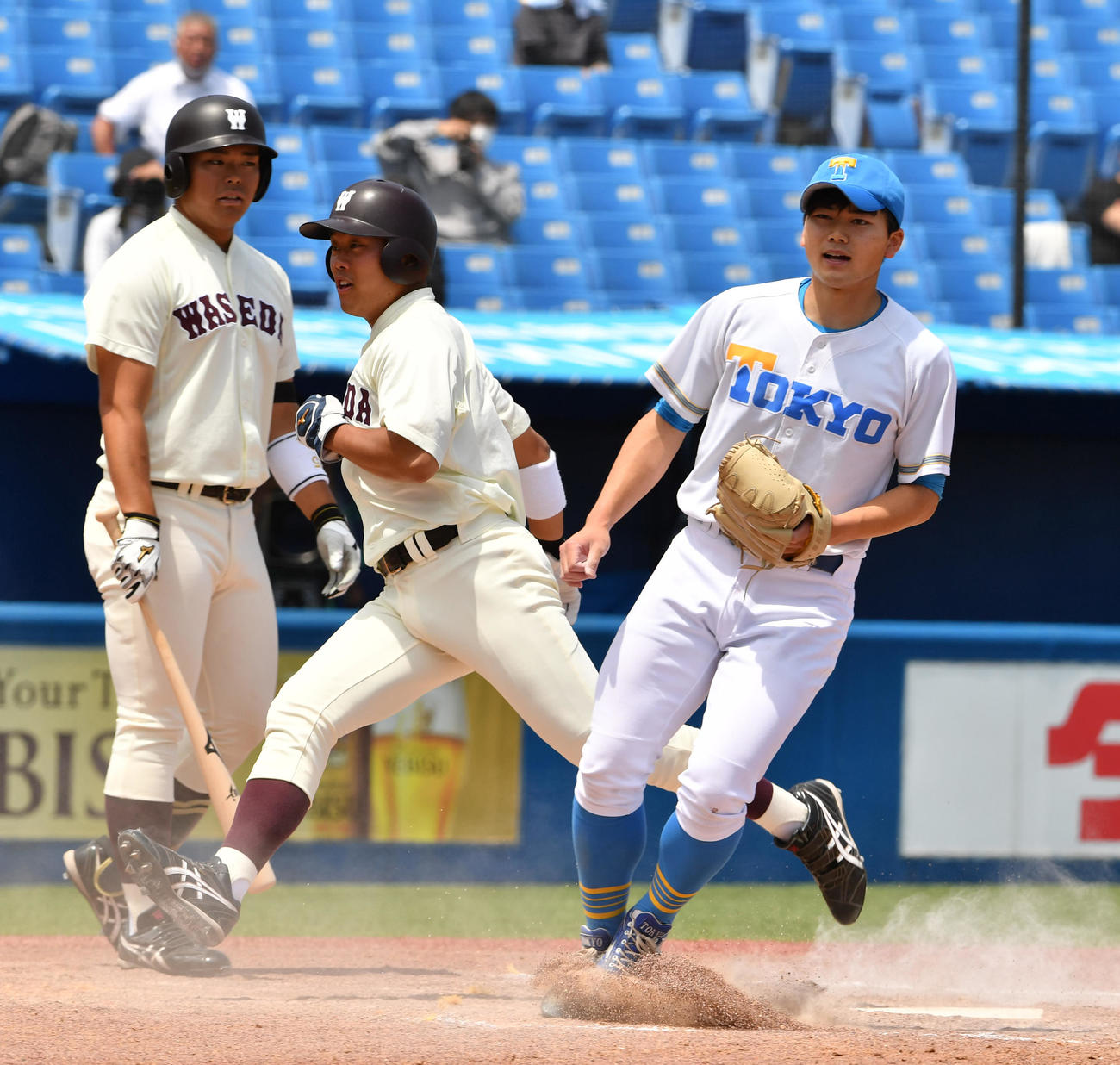 東大対早大　4回裏早大1死一、三塁、打者野村の時、綱嶋（右）のWPで三塁走者蛭間（中央）が生還する（撮影・柴田隆二）