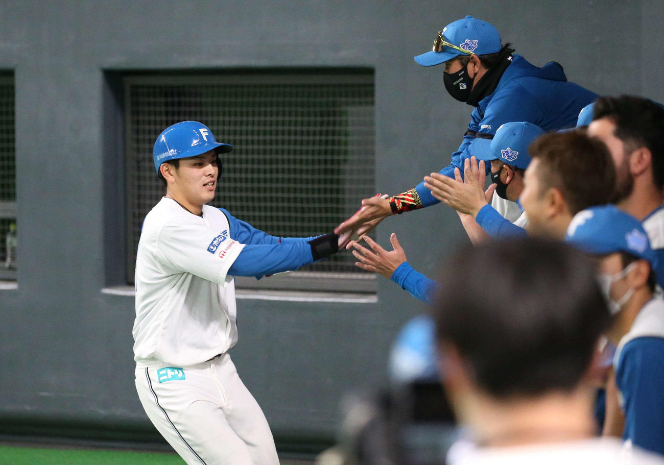 日本ハム対オリックス　4回裏、2点本塁打を放った野村を出迎える新庄監督（撮影・黒川智章）