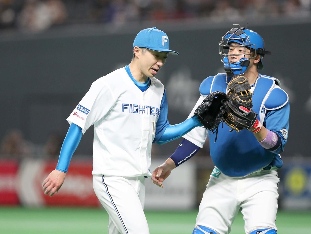 日本ハム対オリックス　3回表、無失点に抑え宇佐見（右）とタッチする金子（撮影・黒川智章）