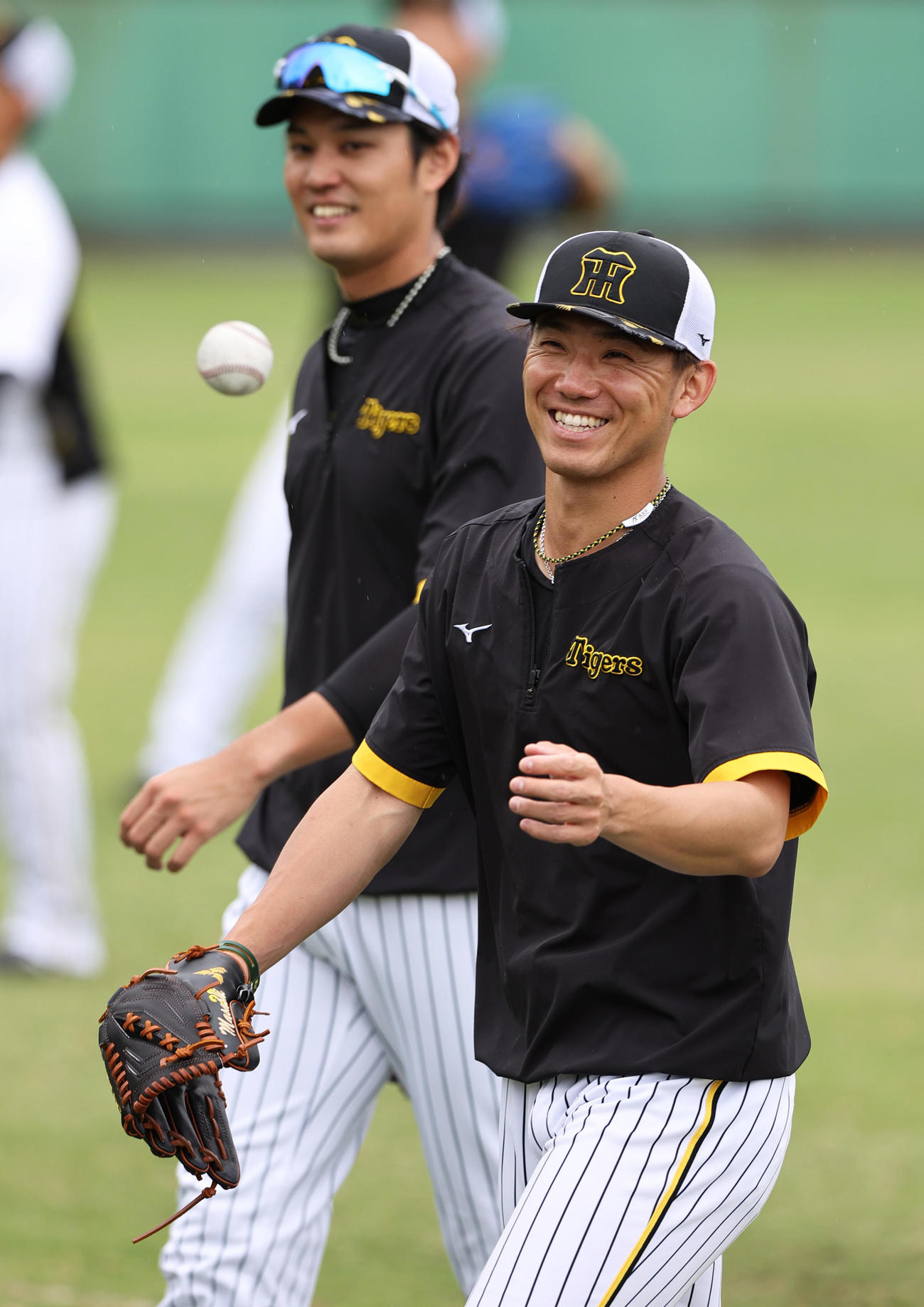 練習中に笑顔を見せる阪神伊藤将（手前）と藤浪（撮影・上山淳一）