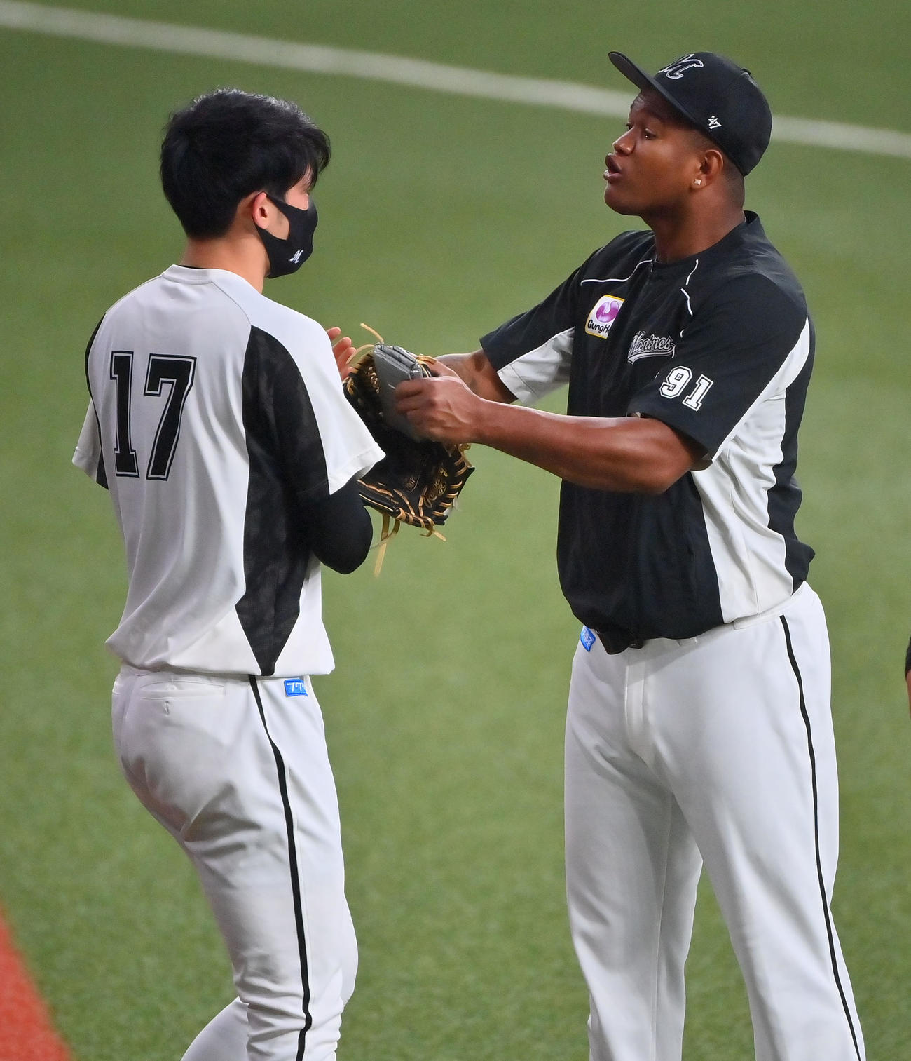 試合前、佐々木朗希（左）とふざけ合うロッテのロメロ（撮影・和賀正仁）