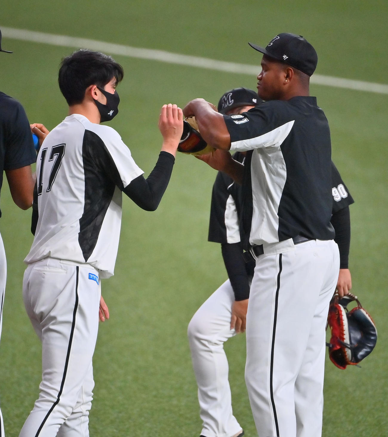 試合前、佐々木朗希（左）とふざけ合うロッテのロメロ（撮影・和賀正仁）