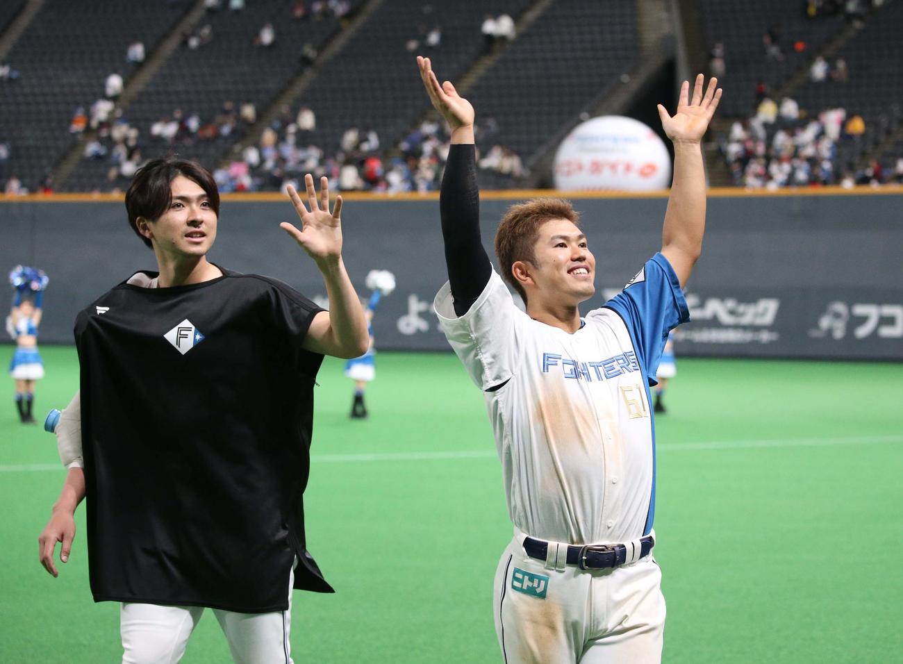 日本ハム対ソフトバンク　試合後、スタンドに向かって手を振る上沢（左）と今川（撮影・黒川智章）