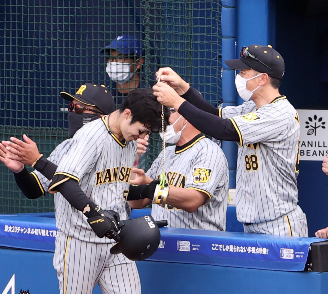 6回表阪神2死二塁、この日2本目の2点本塁打を放ち、矢野監督（右）からメダルをかけられる中野（撮影・狩俣裕三）