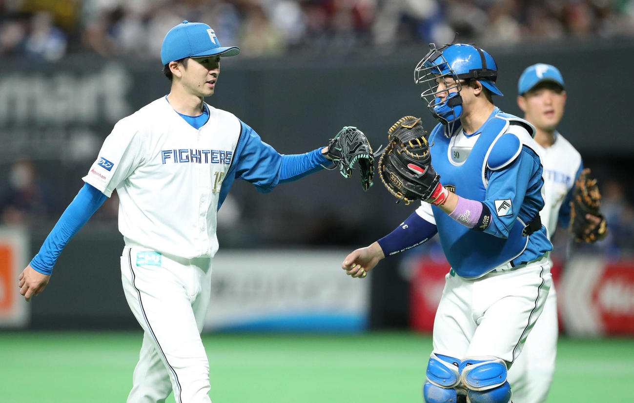 日本ハム対ソフトバンク　7回表を無失点に抑え日本ハム上沢（左）は宇佐見とタッチを交わしながらベンチに戻る（撮影・佐藤翔太）