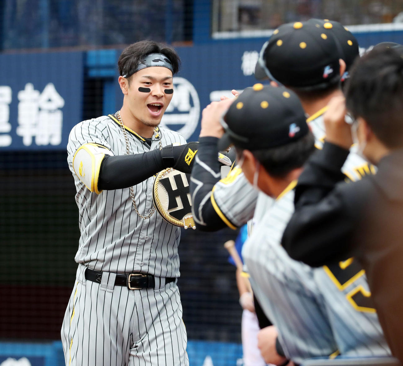 DeNA対阪神　3回表阪神1死、佐藤輝は右越え本塁打を放ちベンチのナインと笑顔でタッチする（撮影・加藤哉）