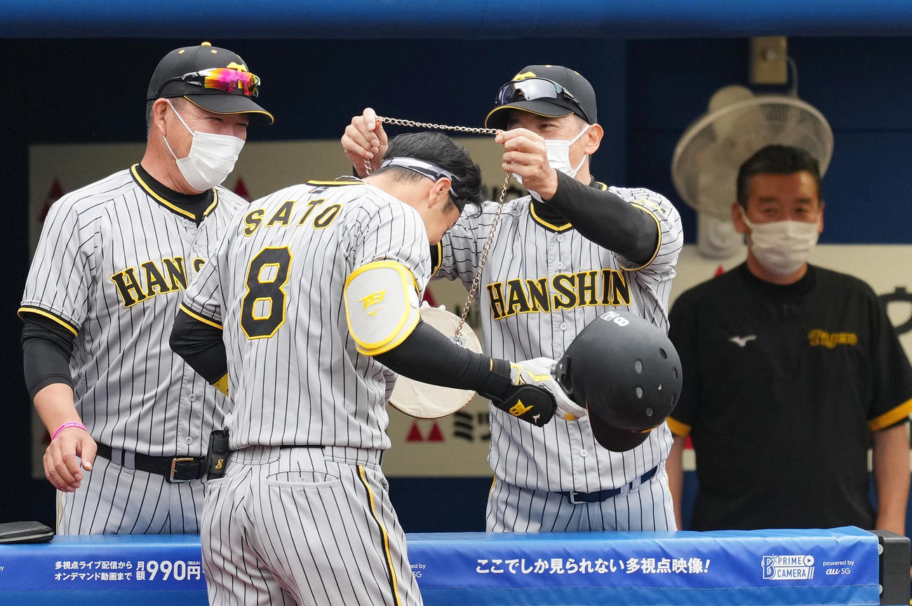 DeNA対阪神　3回表阪神1死、右越えに本塁打を放ち、矢野監督（右から2人目）にメダルをかけられる佐藤輝（撮影・菅敏）