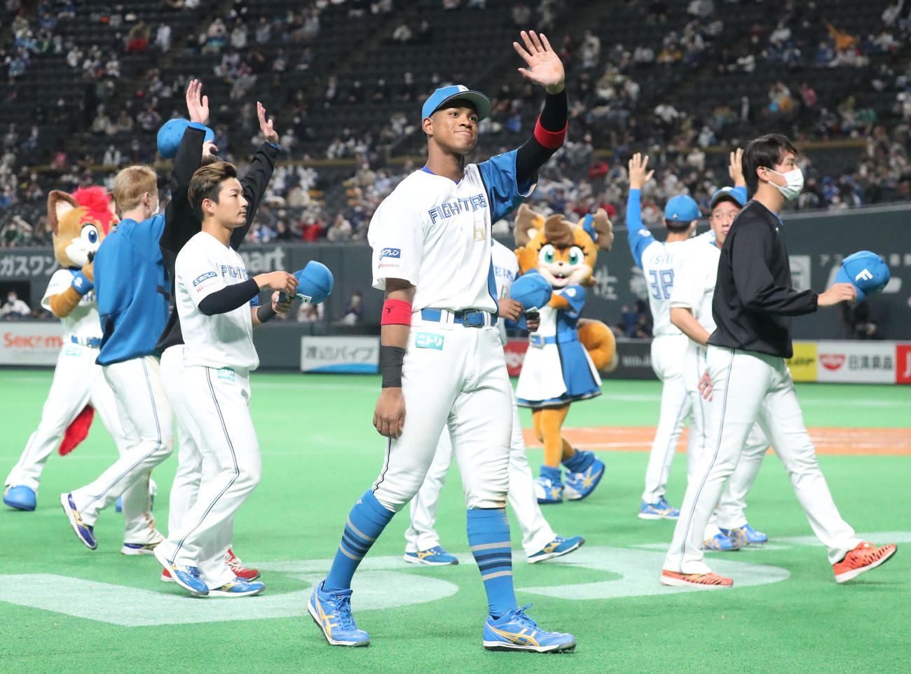 日本ハム対ソフトバンク　試合終了後、スタンド応援席のファンの手を振りながらベンチに引き揚げる日本ハム万波（中央）（撮影・佐藤翔太）
