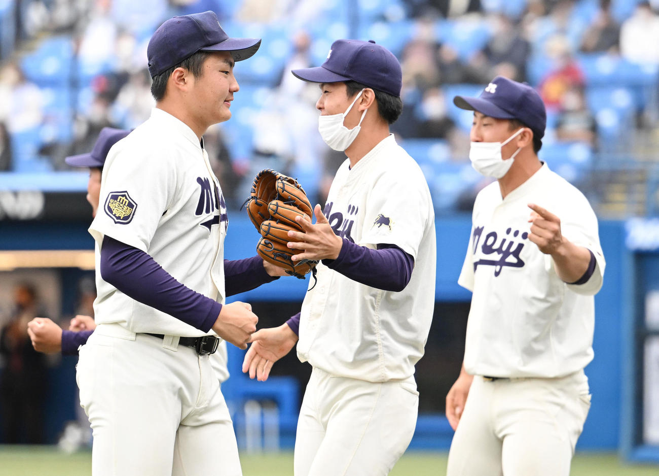 明大対慶大　7回を投げ終えナインとタッチを交わす明大・村田（手前）（撮影・滝沢徹郎）