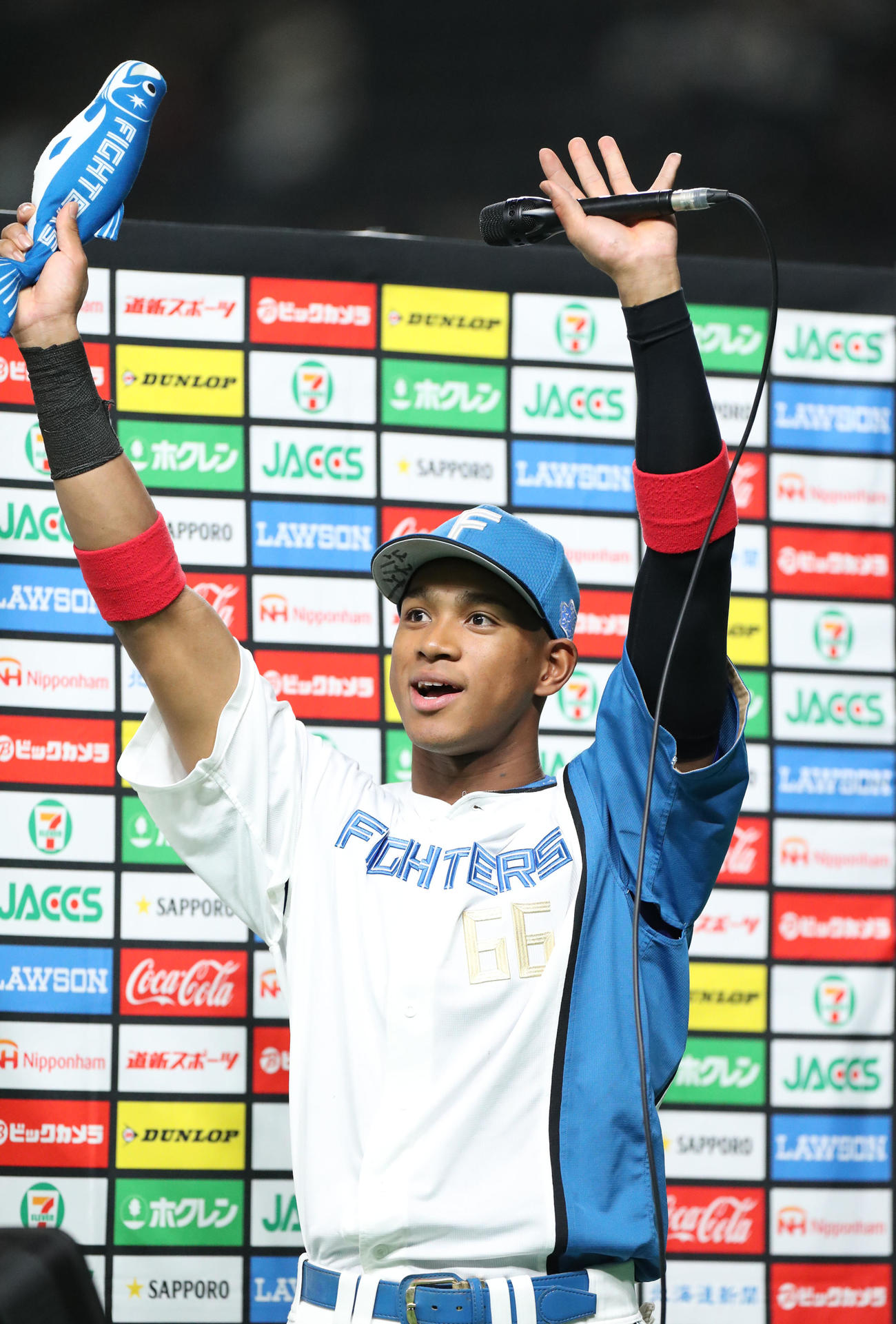 日本ハム対ソフトバンク　新応援グッズ「しゃけまる」を手にスタンド応援席のファンに手を振る日本ハム万波（撮影・佐藤翔太）