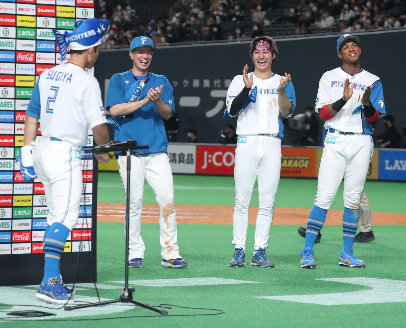 日本ハム対ソフトバンク　新応援グッズの「しゃけまる」を身に着けた日本ハム杉谷（左手前）のインタビューに爆笑する左から松本剛、浅間、万波（撮影・佐藤翔太）