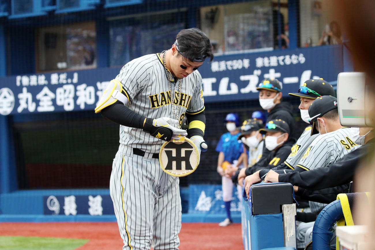 DeNA対阪神　6回表阪神無死、佐藤輝はこの試合2本目となる中越え本塁打を放ち、メダルのロゴマーク部分が回転することを見せてくれた（撮影・加藤哉）