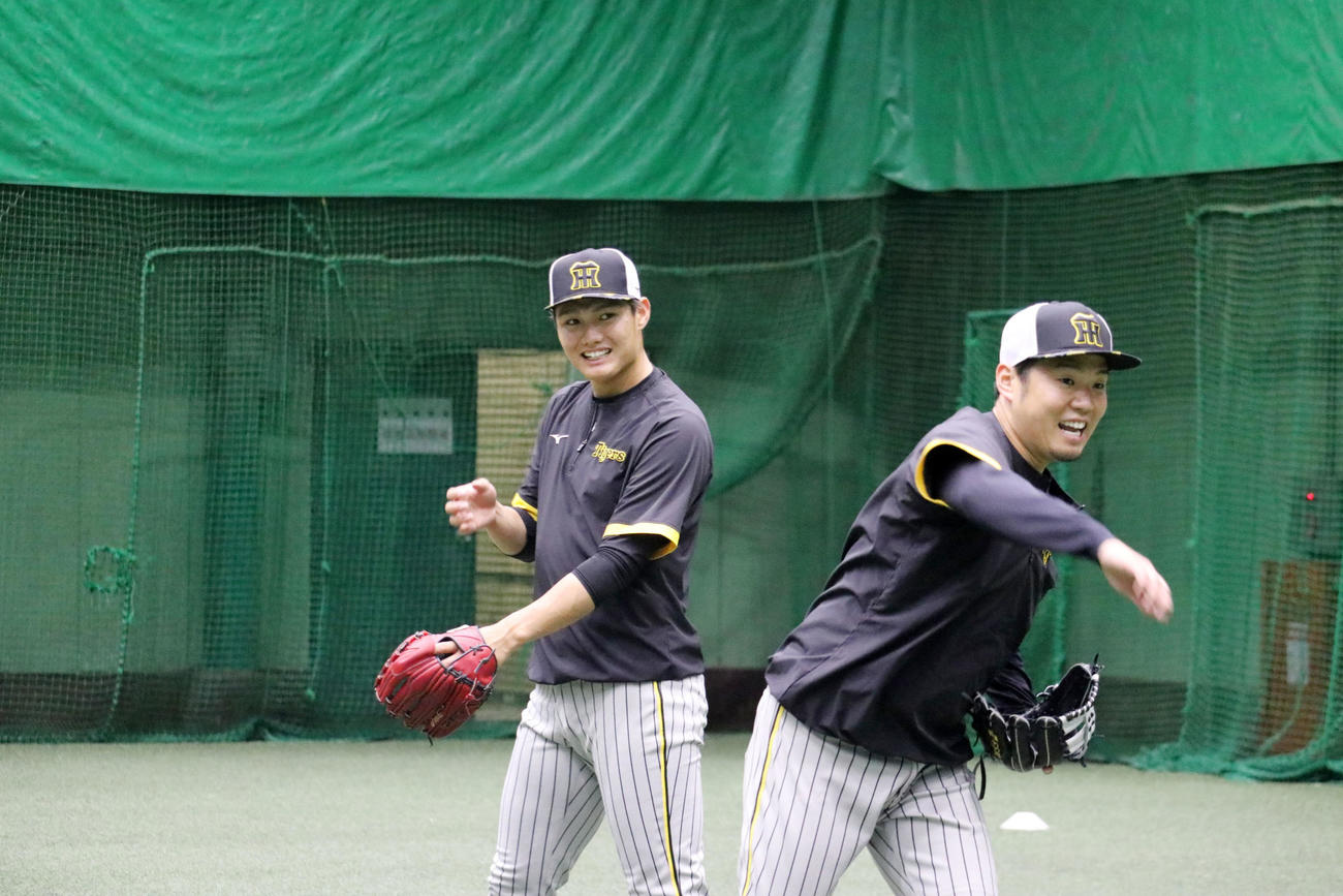 ノックを受けながら笑顔を見せる西勇（左）と西勇（球団提供）