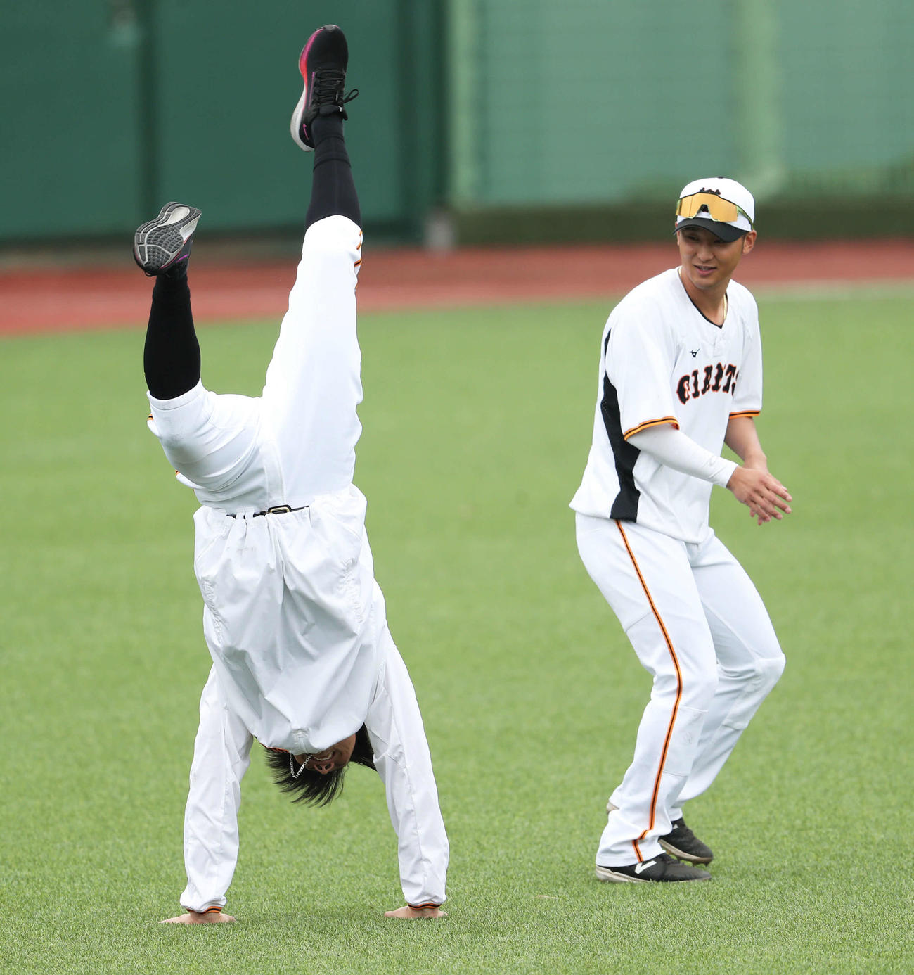 巨人対広島　試合前、逆立ちする小林（左）に驚く巨人吉川（撮影・河田真司）