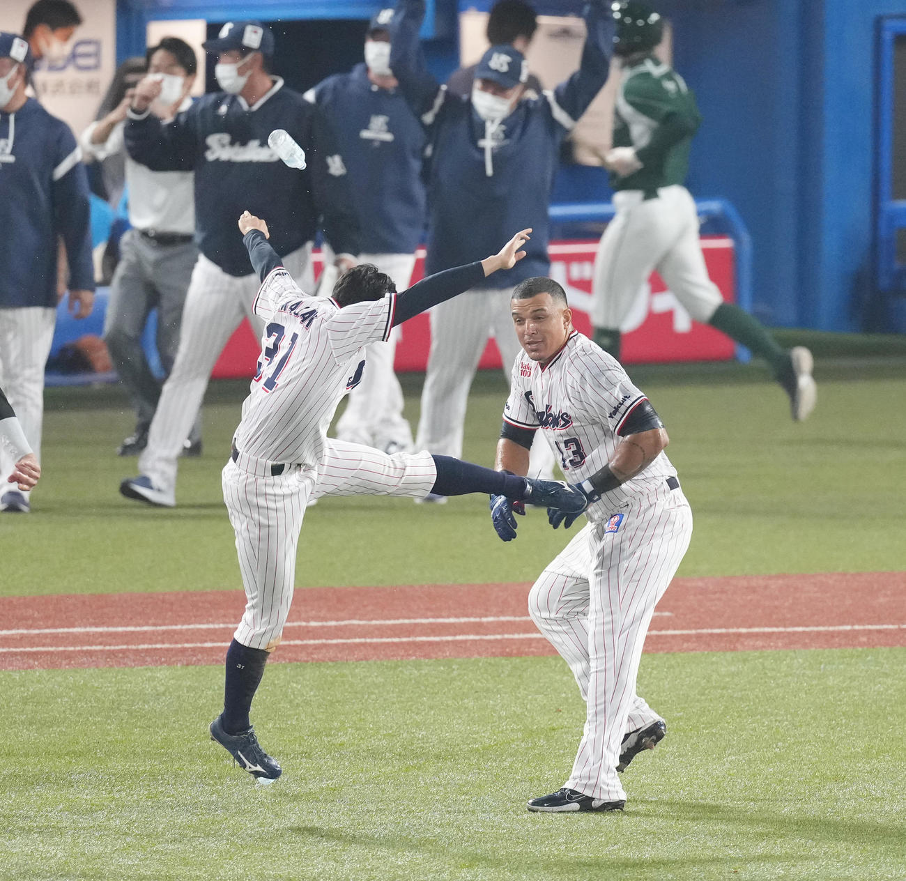 ヤクルト対阪神　9回裏ヤクルト1死二、三塁、サヨナラ犠飛を放ったオスナ（右）は山崎から祝福のキックを見舞われる（撮影・菅敏）